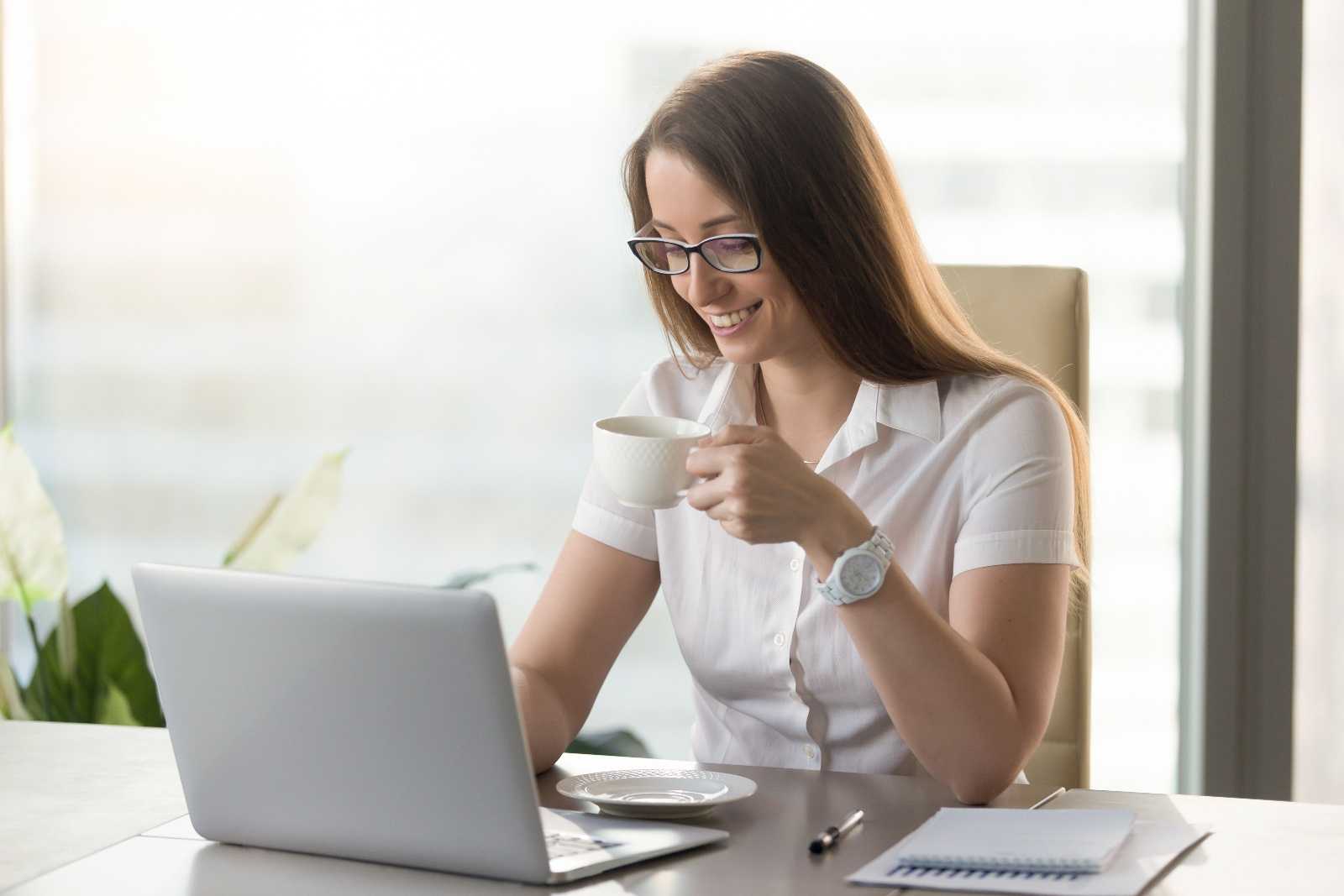 Организатор на компьютер. Офис работница счастливая пьет чай. Businesswoman drinking Coffee.